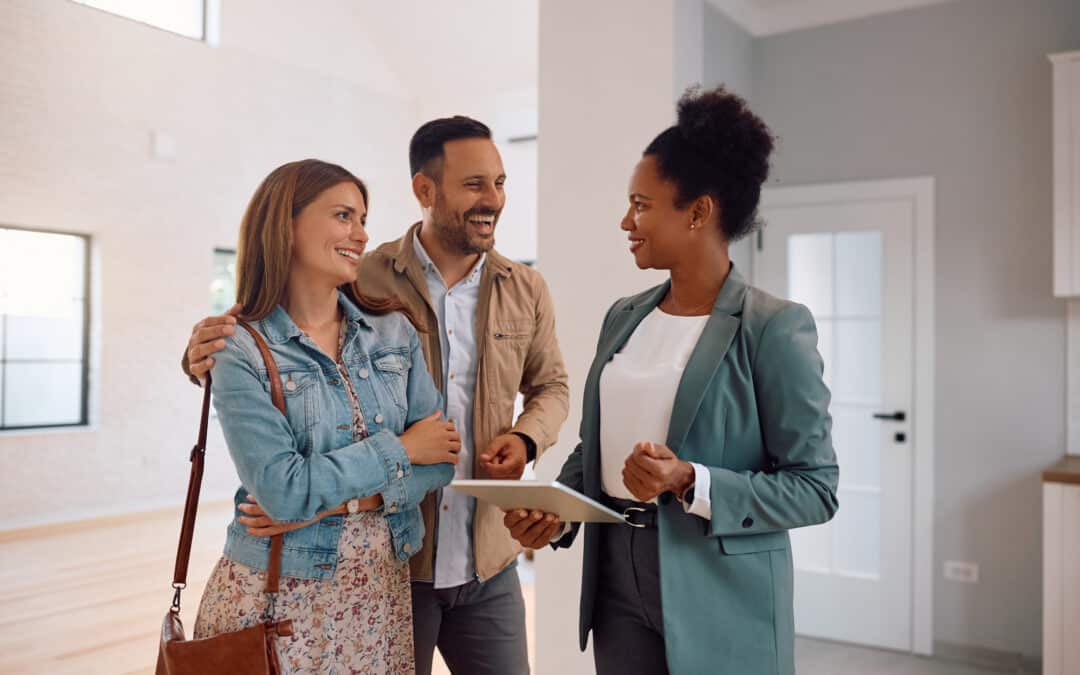 Happy Couple And Real Estate Agent Using Digital Tablet During Open House Day.