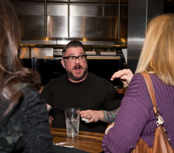 Work Culture At Attom Employees talking during a social event.