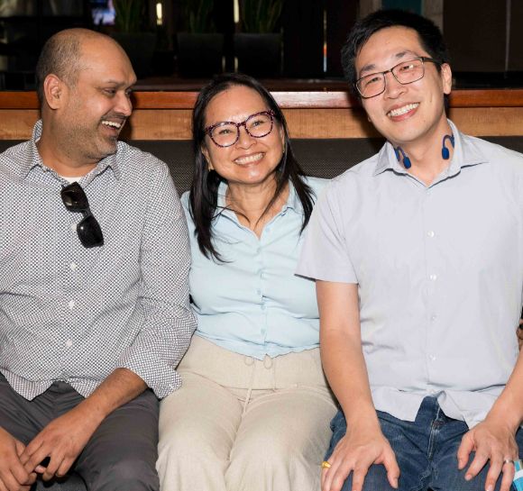 Three company employees posing for a photo smiling